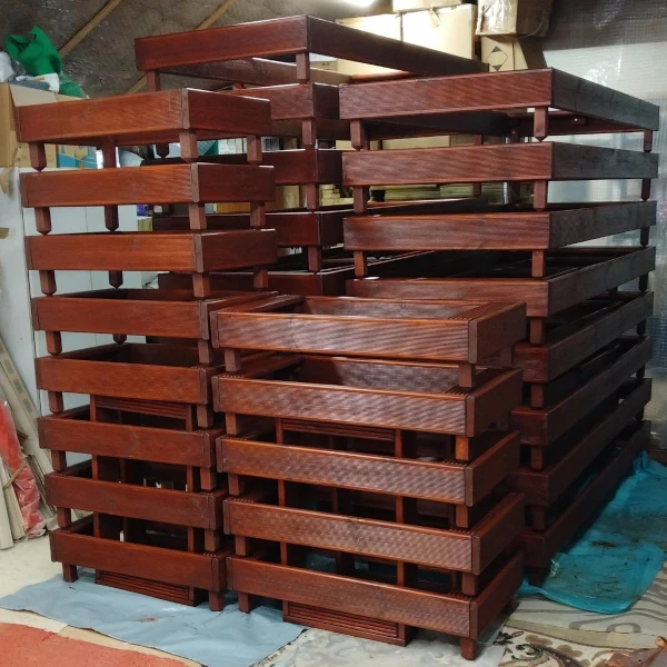 Stack of dark stained wooden grave markers stacked up.