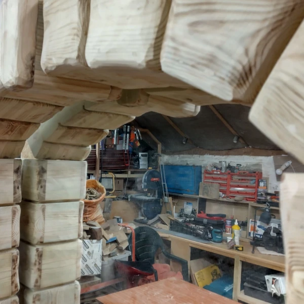 Top of wooden arch made to look like it's made from stone blocks.